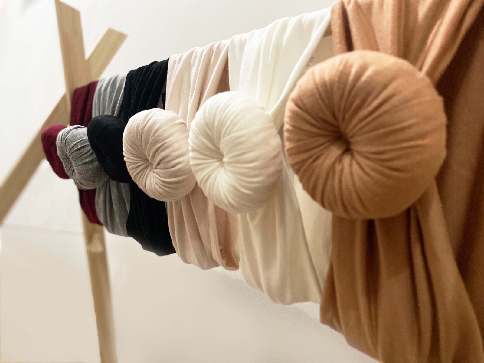 A collection of Tiny Knot Co headbands displayed on a clothesline.