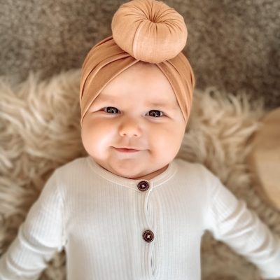 A baby wearing a Tiny Knot Co - Bamboo Baby Knotted Headwrap.