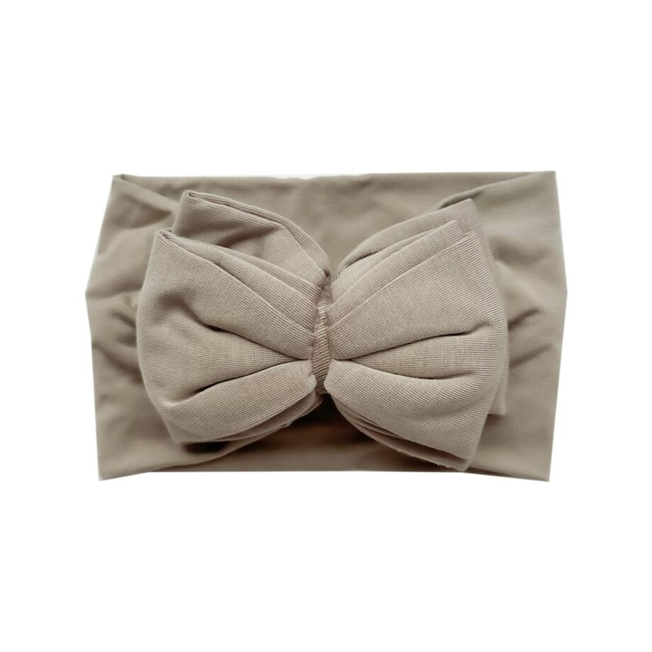 A Tiny Knot Co beige Bamboo Baby Knotted Headwrap with a bow on it.