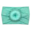 An Isla   Bamboo Baby Knotted Headwrap headband with a Tiny Knot Co ball on it 