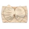 Nora   Bamboo Baby Knotted Headwrap by Tiny Knot Co, a beige headband with a bow on it 