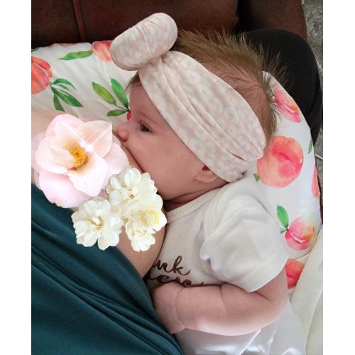 A baby is breastfeeding with Lola, Blush - Bamboo Baby Knotted Headwrap from Tiny Knot Co on her head.