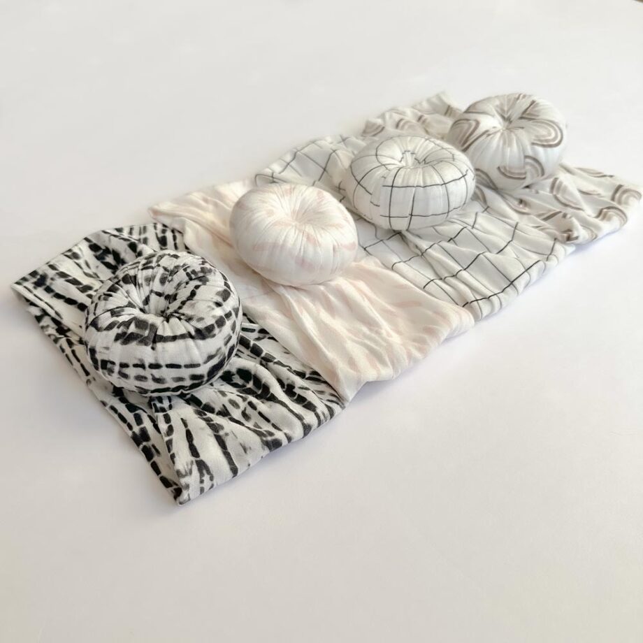 A set of Tiny Knot Co pillows on a white surface.