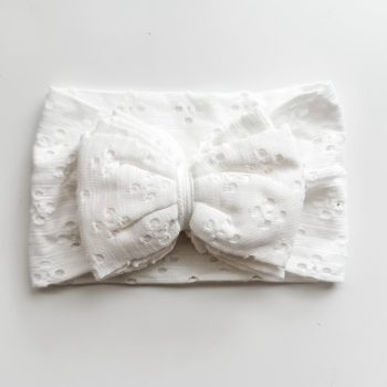A white headband with a bow on it.