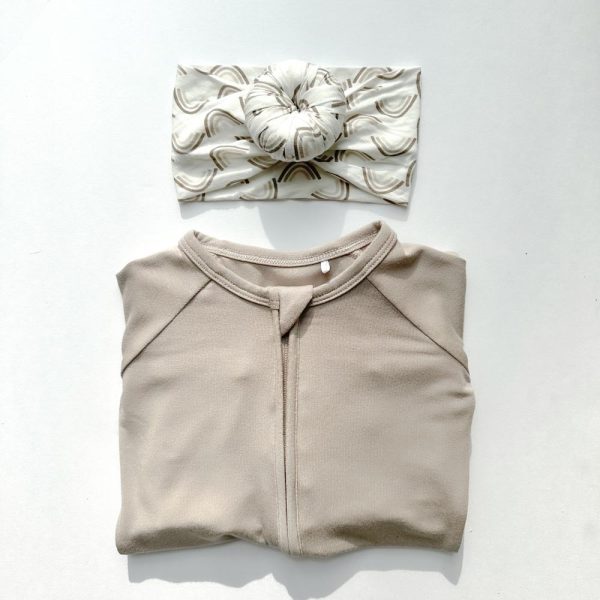 A beige top and headband by Tiny Knot Co on a white surface.