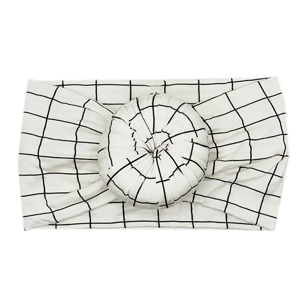 A Tiny Knot Co Ellie Bamboo Baby Knotted Headwrap with a black and white checkered pattern