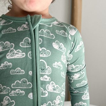 A child wearing a Tiny Knot Co Happy Skies Zippered Romper.