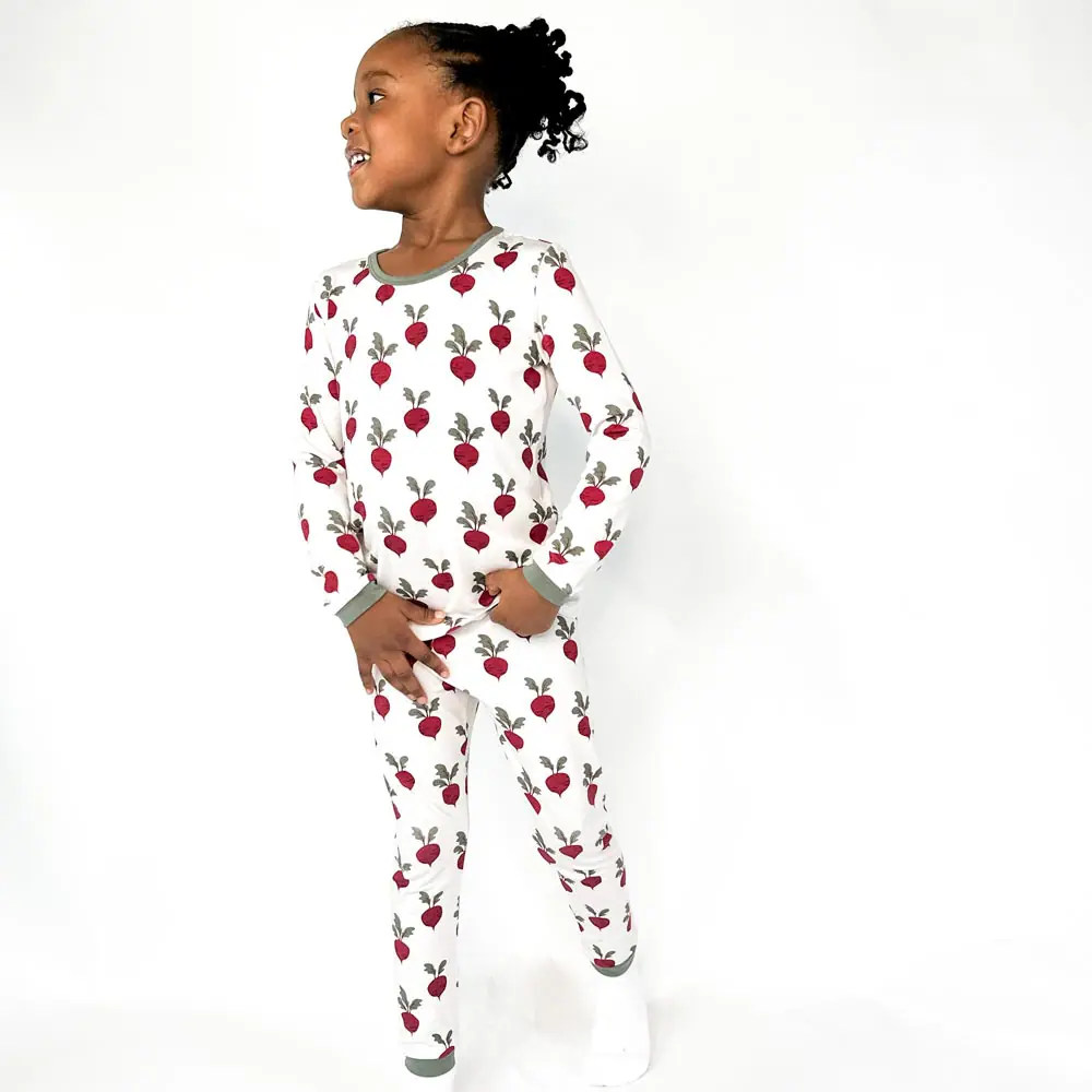 Smiling child in super soft TENCEL™ beet print pajamas, Tiny Knot Co